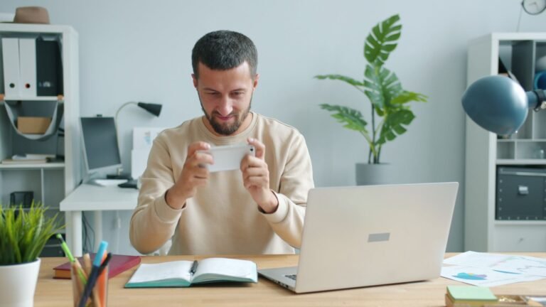 شخص يستخدم هاتفًا ذكيًا في مكتب