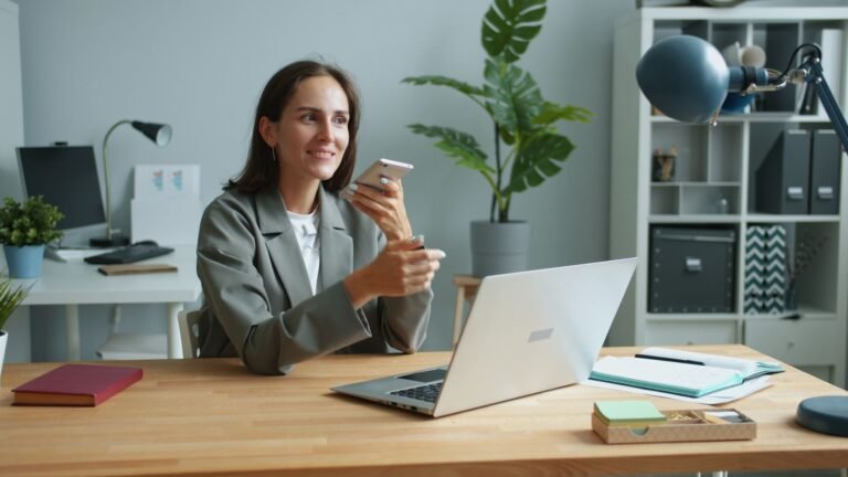 سيدة أعمال تستخدم هاتفًا وحاسوبًا محمولًا